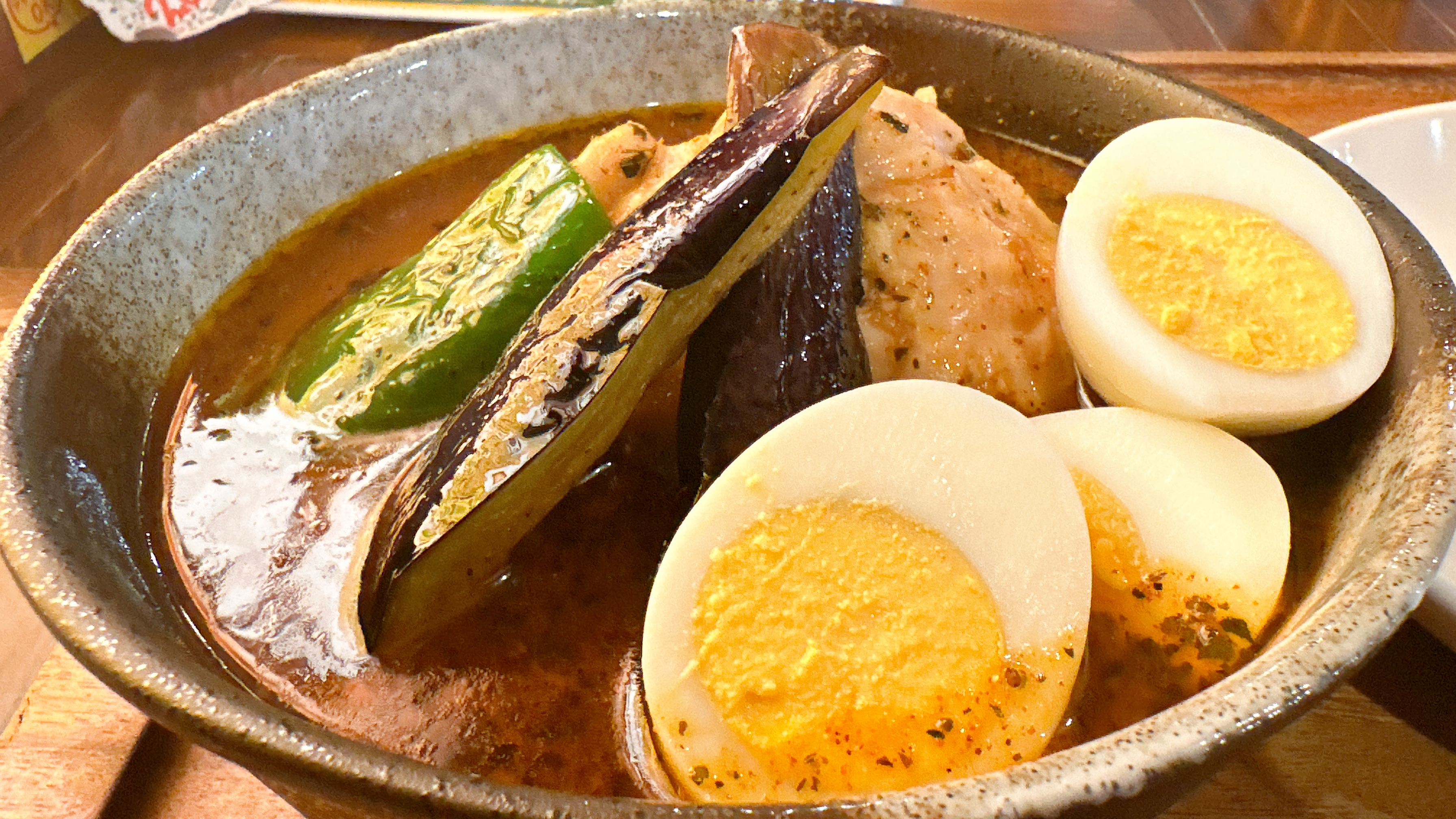 東京スープカレーの聖地・下北沢で毎日楽しめる人気店 心 下北沢店 皮ごとじゃがいも・ニンジン・ピーマン・旨味たっぷりチキン・揚げナス・ゆで卵追加